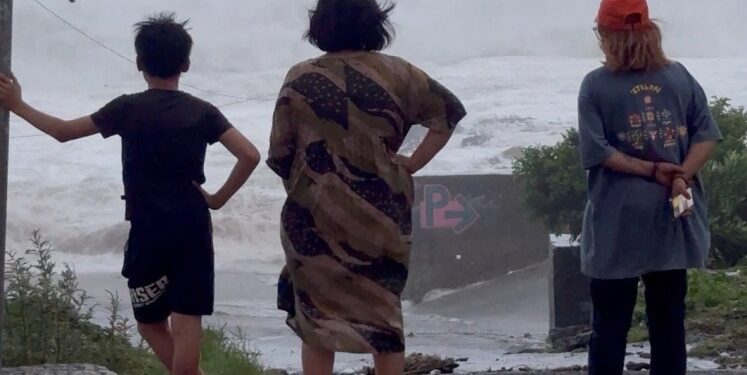 La gente que vio enormes olas se estrella cuando el súper tifón Ragasa trae lluvia a Orchid Island, Taiwán.
