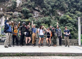 Un grupo de turistas saluda mientras se va a pie debido a una protesta en Machu Picchu Pueblo.