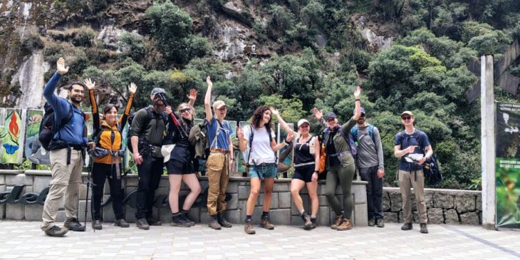 Un grupo de turistas saluda mientras se va a pie debido a una protesta en Machu Picchu Pueblo.