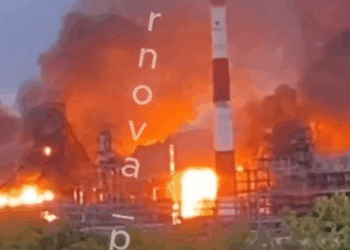 Una planta química en llamas con una gran humo de rayas roja y blanca.