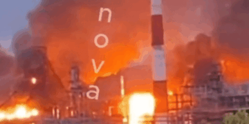 Una planta química en llamas con una gran humo de rayas roja y blanca.