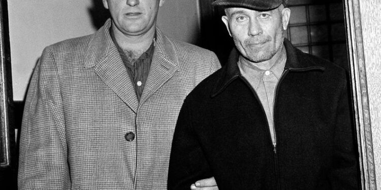 El sheriff del condado de Waushara, Art Schley, escorts Edward Gein al Hospital Central del Estado.