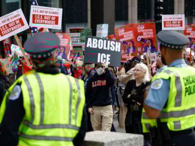 Los oficiales de policía observan mientras las personas participan en una manifestación contra el despliegue planificado de tropas de la Guardia Nacional en Chicago