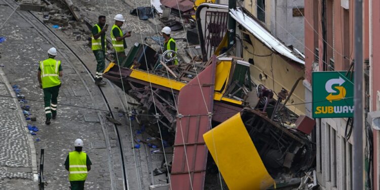 Escombros de un funicular descarrilado en Lisboa, Portugal, con trabajadores en el sitio.