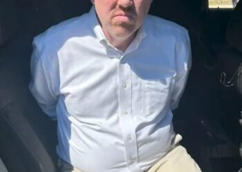 Dr. William Murdoch en las esposas después del arresto.