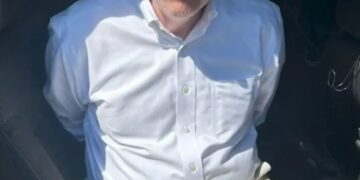 Dr. William Murdoch en las esposas después del arresto.