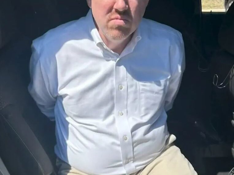 Dr. William Murdoch en las esposas después del arresto.