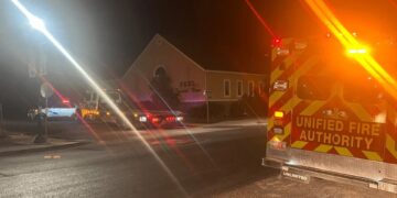 Vehículos de emergencia fuera de la funeraria Peel Funeral por la noche.