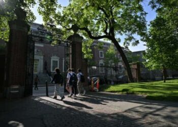 Un grupo de estudiantes pasa por una puerta que sale de Harvard Yard el 27 de mayo de 2025, en Cambridge, Massachusetts.