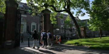 Un grupo de estudiantes pasa por una puerta que sale de Harvard Yard el 27 de mayo de 2025, en Cambridge, Massachusetts.