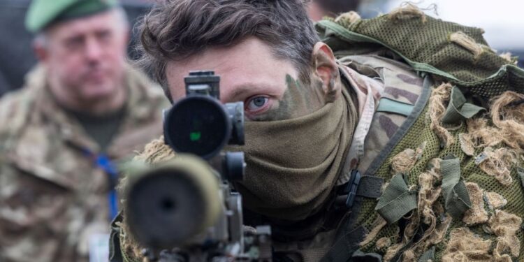 Un soldado apuntando a un rifle de francotirador durante un ejercicio militar.