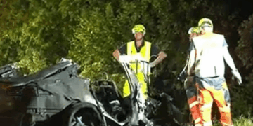 El personal de emergencia atiende a un vehículo Tesla severamente dañado y quemado después de un accidente fatal.