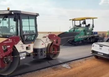 Escena de construcción de carreteras con un vapor y una máquina de pavimento.