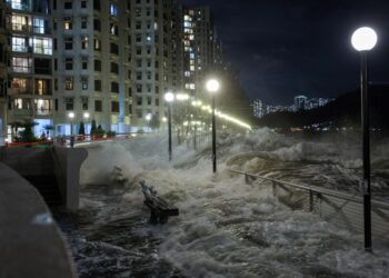Las olas del Super Typhoon Ragasa se estrellan contra las sillas junto a la orilla en Hong Kong.