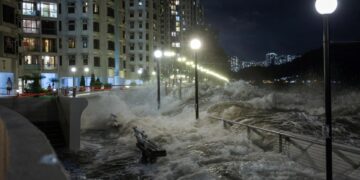 Las olas del Super Typhoon Ragasa se estrellan contra las sillas junto a la orilla en Hong Kong.