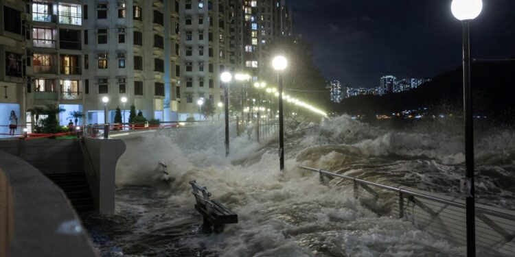 Las olas del Super Typhoon Ragasa se estrellan contra las sillas junto a la orilla en Hong Kong.