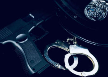 El sombrero de un oficial de policía, las esposas y el arma.