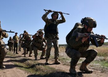 Reclutas de la 65ª Brigada Mecanizada separada de las Fuerzas Armadas ucranianas que asisten a un simulacro militar cerca de una primera línea.