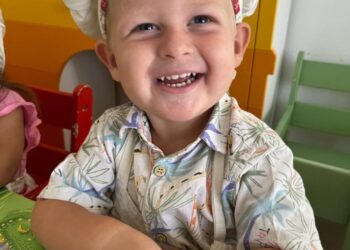 Extrañando el niño británico Oliver Pugh con un sombrero de chef y una camisa estampada, sonriendo.