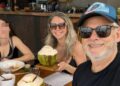 Flavia McDonald, su esposo y su hija Lorena disfrutando de una comida con bebidas de coco frescas.