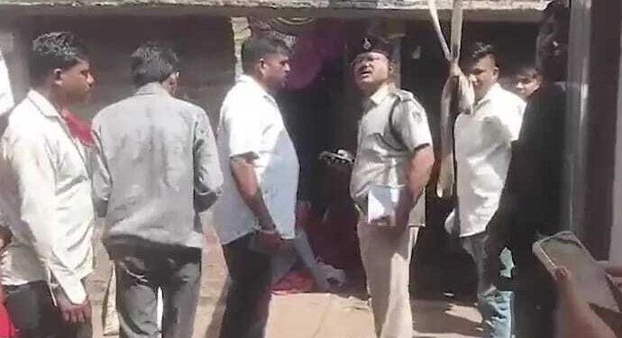 Oficial de policía que habla con personas fuera de una casa.