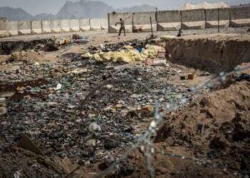 Un soldado del Ejército Nacional Afgano (ANA) pasa junto a un pozo de quemaduras en un puesto avanzado de comando recientemente entregó a la ANA desde el ejército de los Estados Unidos el 22 de marzo de 2013 en la provincia de Kandahar, distrito de Zhari, Afganistán.