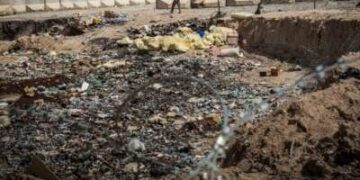 Un soldado del Ejército Nacional Afgano (ANA) pasa junto a un pozo de quemaduras en un puesto avanzado de comando recientemente entregó a la ANA desde el ejército de los Estados Unidos el 22 de marzo de 2013 en la provincia de Kandahar, distrito de Zhari, Afganistán.