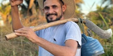 Reinaldo da Silva Melo, también conocido como el "Rey de Juquira" Influencer, llevando una guadaña sobre su hombro.