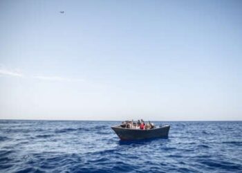 Un bote solitario que transporta inmigrantes flotadores en el Mediterráneo