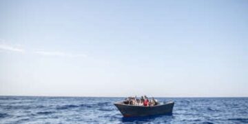Un bote solitario que transporta inmigrantes flotadores en el Mediterráneo
