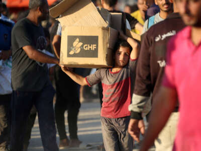 Un niño que lleva una parcela de ayuda, camina por la carretera Salah al-Din, cerca del campo de refugiados de Nusseirat en la franja central de Gaza, utilizado por los palestinos que buscan alimentos para alcanzar un punto de distribución de ayuda establecido por la Fundación Humanitaria de Gaza privada (GHF), el 25 de junio de 2025.