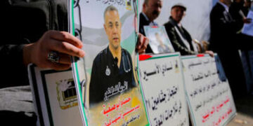 Los manifestantes tienen pancartas y fotografías del Dr. Hossam Abu Safiya durante una sentada en Hebrón en Cisjordia ocupada por Israeli el 9 de enero de 2025.