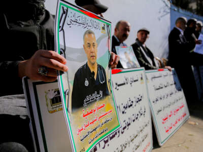 Los manifestantes tienen pancartas y fotografías del Dr. Hossam Abu Safiya durante una sentada en Hebrón en Cisjordia ocupada por Israeli el 9 de enero de 2025.
