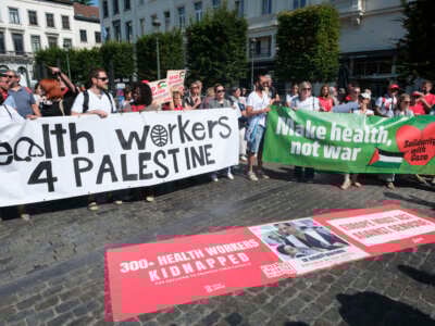 Alrededor de 150 personas demuestran un cese inmediato e incondicional de los ataques contra la infraestructura de salud y el personal frente al Parlamento Europeo el 19 de junio de 2025 en Bruselas, Bélgica.