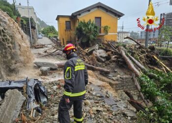 Un bombero examina una calle inundada y cubierta de escombros en Como, Italia.