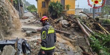 Un bombero examina una calle inundada y cubierta de escombros en Como, Italia.