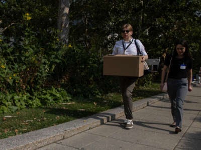Recientemente despedidos de los empleados del Departamento de Estado de EE. UU. Llevan cajas mientras salen del Edificio Federal de Harry S. Truman el 11 de julio de 2025 en Washington, DC