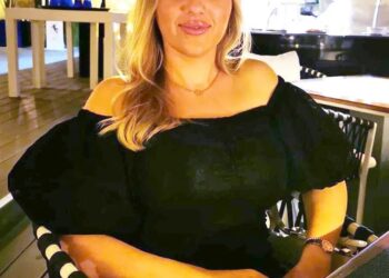 Mujer sentada en un restaurante al aire libre.