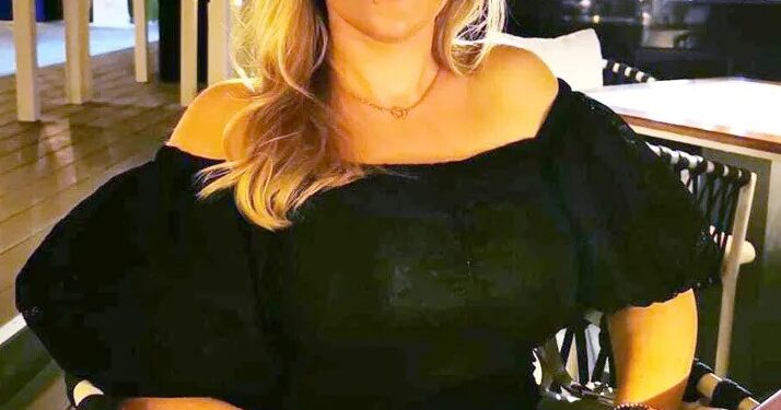 Mujer sentada en un restaurante al aire libre.