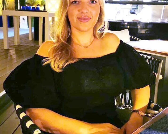 Mujer sentada en un restaurante al aire libre.