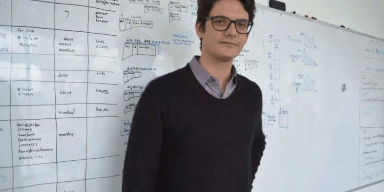 Matias Augusto Travizano se encuentra frente a una pizarra llena de notas y diagramas.