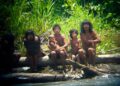 Miembros de la tribu Mashco-Piro que observan viajeros desde el otro lado de un río.