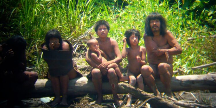 Miembros de la tribu Mashco-Piro que observan viajeros desde el otro lado de un río.