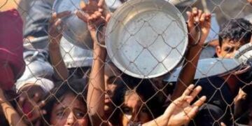 Los palestinos, en su mayoría niños, presionan para recibir una comida caliente en una cocina benéfica en el área de Mawasi de Khan Yunis en el Southern Gaza Strip el 22 de julio de 2025.