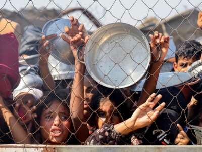 Los palestinos, en su mayoría niños, presionan para recibir una comida caliente en una cocina benéfica en el área de Mawasi de Khan Yunis en el Southern Gaza Strip el 22 de julio de 2025.