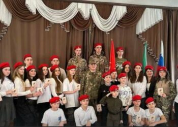 Grupo de niños y adultos con boinas rojas.