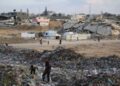 La gente examina la basura cerca de las tiendas y refugios improvisados ​​en el campamento de Bureij para refugiados palestinos en la Franja de Gaza el 21 de septiembre de 2025.