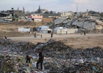 La gente examina la basura cerca de las tiendas y refugios improvisados en el campamento de Bureij para refugiados palestinos en la Franja de Gaza el 21 de septiembre de 2025.