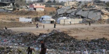 La gente examina la basura cerca de las tiendas y refugios improvisados en el campamento de Bureij para refugiados palestinos en la Franja de Gaza el 21 de septiembre de 2025.