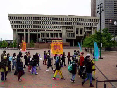 Personas en abrigos marchando con señales